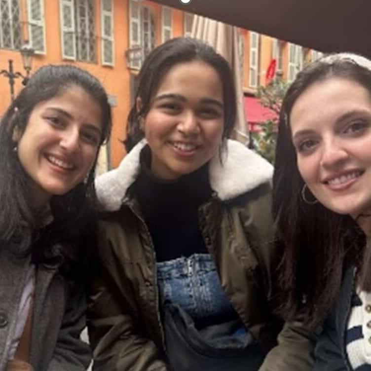 Three girls smile and pose for the camera.